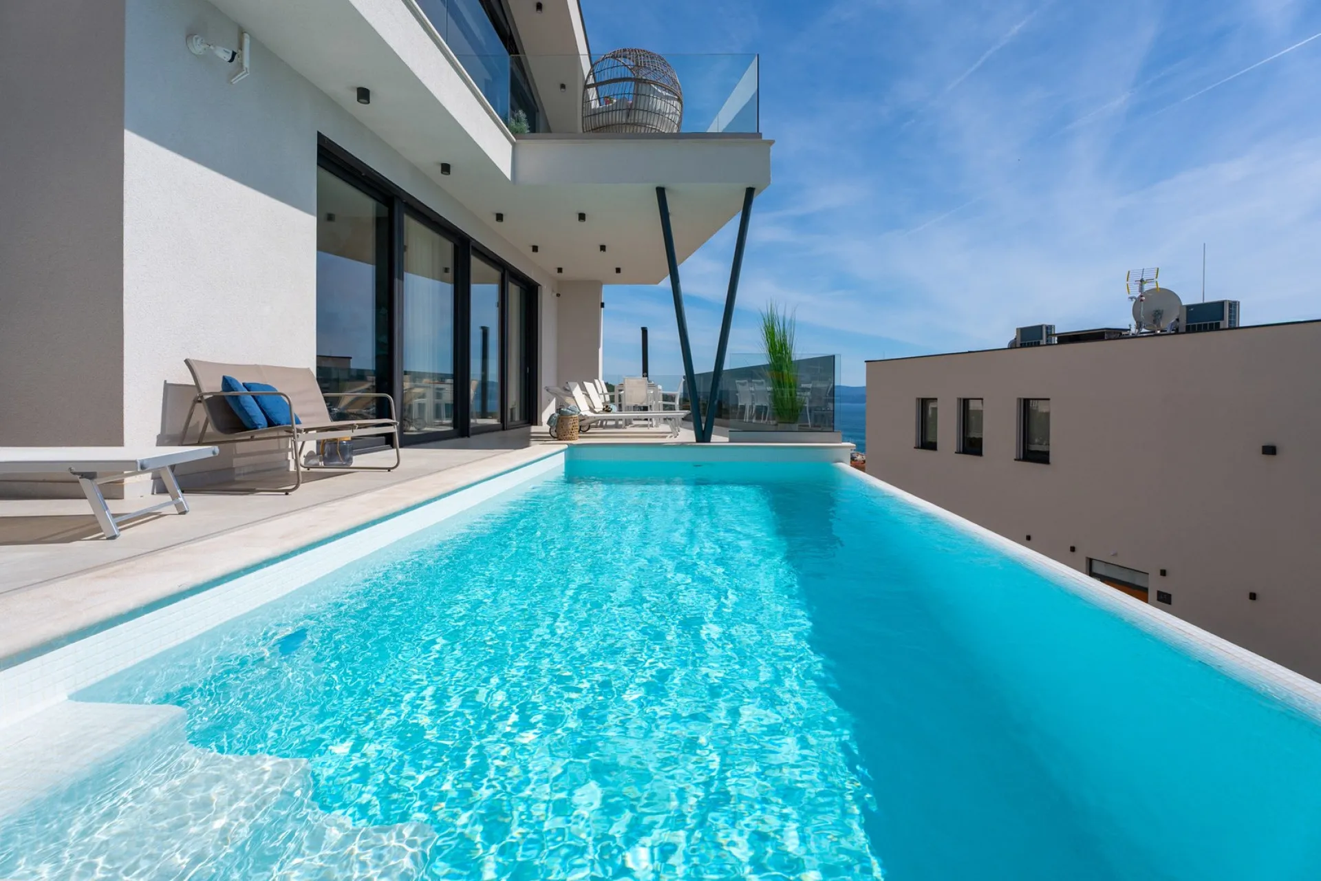 Villa Flower, Poolterrasse mit Liegen und Blick auf die Adria
