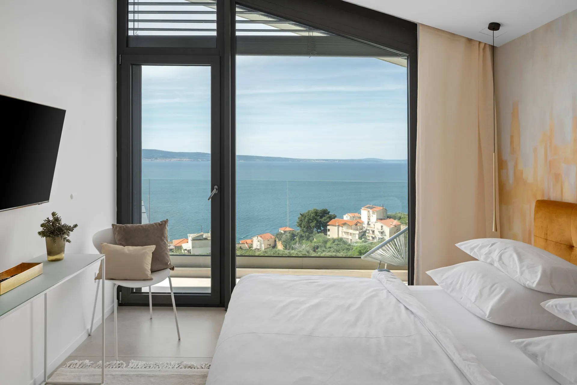 Schlafzimmer mit bodentiefem Fenster und Meerblick