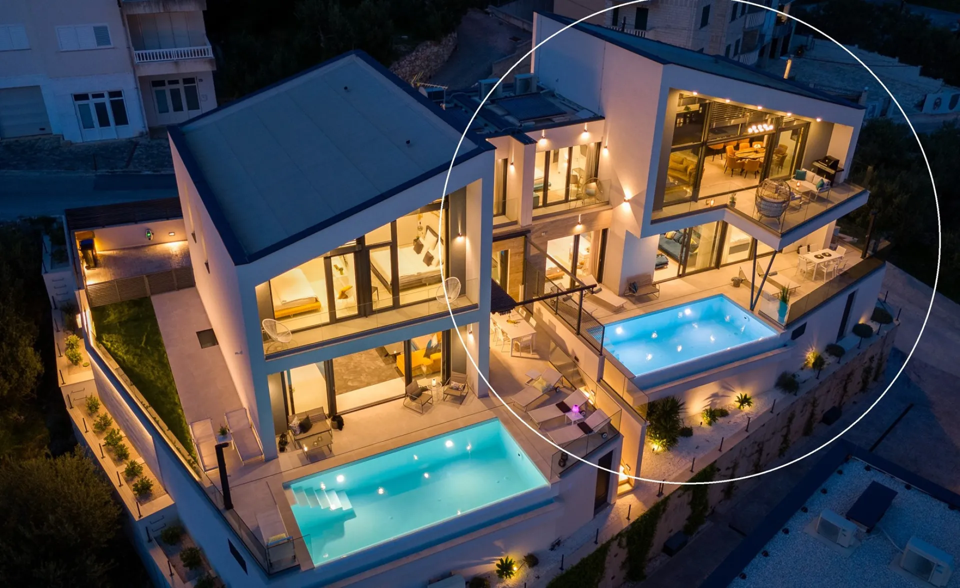 Die Anlage am Abend von oben, mit beleuchtetem Pool